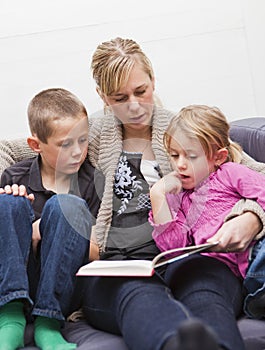 Mother reading a book to her children