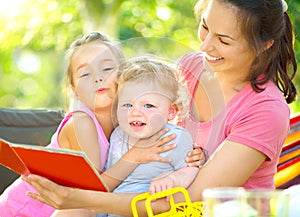 Mother reading a book to her children