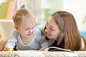 Mother reading a book to kid at home