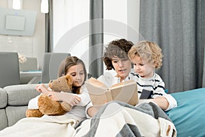 Mother Reading Book to Kids