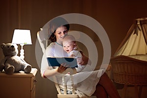 Mother reading a book to little baby