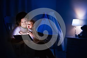 Mother reading a book to little baby