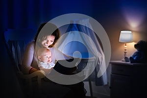 Mother reading a book to little baby