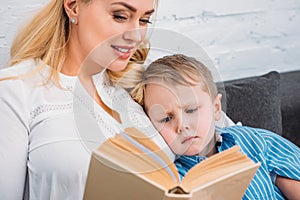 Mother reading book to upset little