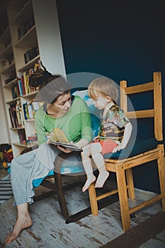 Mother reading with her son at home, casual,