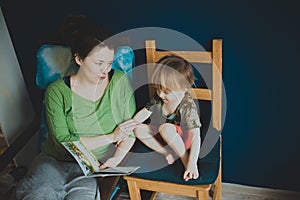 Mother reading with her son at home, casual,