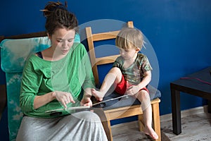 Mother reading with her son at home, casual,