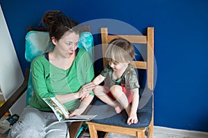 Mother reading with her son at home, casual,