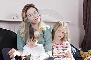 Mother reading to kids in bed