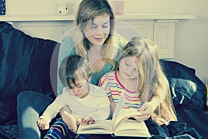 Mother reading to kids in bed