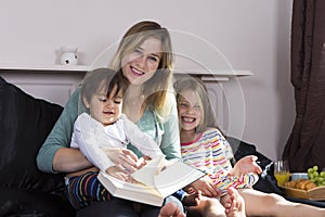 Mother reading to kids in bed