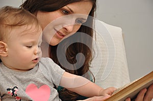 Mother reads a book to a baby daughter