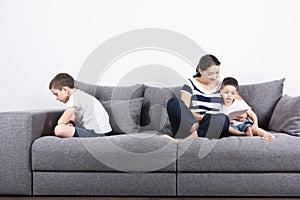 Mother reads an interesting book with her sons. Jealousy concept.