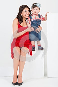 Mother in a red dress with little daughter in