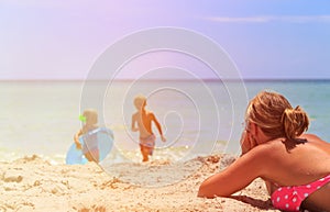 Mother relax while kids play with water at beach