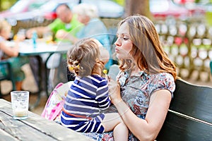 Mother relaxing together with her little child, adorable toddler girl