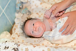 Mother rubs baby after bathing. the boy smiles and feels happy after taking a bath. mother dries and rubs the hair of the newborn