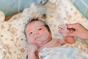 Mother rubs baby after bathing. the boy smiles and feels happy after taking a bath. mother dries and rubs the hair of the newborn