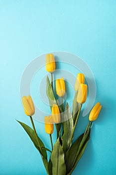 Mother`s day background concept. Top view design of holiday greeting tulip flower bouquet on bright blue table background