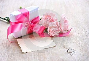 Mother`s Day background, gift box, three pink carnations, paper