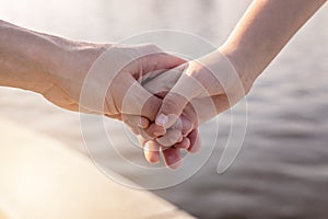 Mother`s day concept. Girl holding her mother`s hand. Happy family