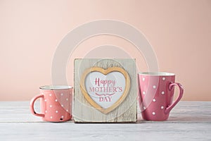 Mother`s day concept with photo heart shape frame and coffee cup on wooden table