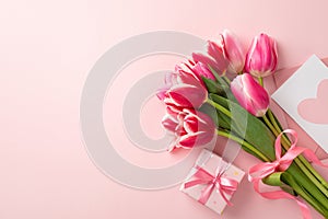 Top view photo of bunch of pink tulips tied with ribbon small giftbox with bow and envelope with postcard