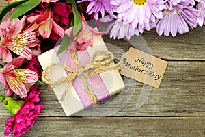 Mother's Day gift box and flowers on wood