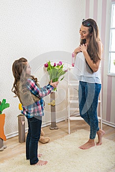 Mother's Day - Girl gives her mom a big bouquet of tulips, touching