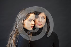 Mother`s Day. Happy mom and adult daughter, beautiful girls, portrait on black background