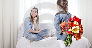 Mother`s day. Little daughter with flowers congratulates her mother