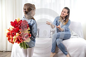 Mother`s day. Little daughter with flowers congratulates her mother