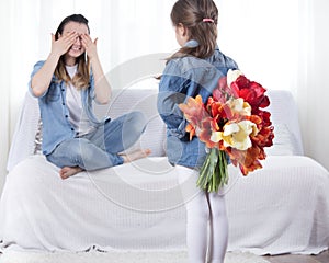 Mother`s day. Little daughter with flowers congratulates her mother