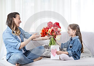 Mother`s day. Little daughter with flowers congratulates her mother