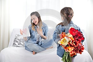 Mother`s day. Little daughter with flowers congratulates her mother