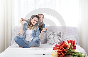 Mother`s day. Little daughter with flowers congratulates her mother