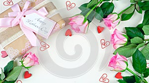 Mother`s Day overhead with gift and pink roses on white wood table background