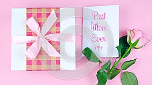 Mother`s Day overhead with rose, Best Mom Ever card and gift on pink table.