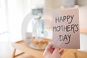 Mother's day still life with hand holding a greeting card