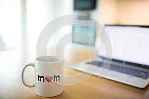 Mother\'s day still life with mom cup and an open laptop