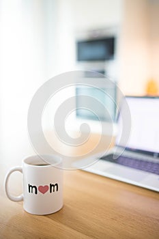 Mother\'s day still life with mom cup and an open laptop