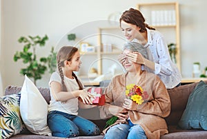 Mother`s day! three generations of  family mother, grandmother and daughter congratulate on the holiday, give flowers photo