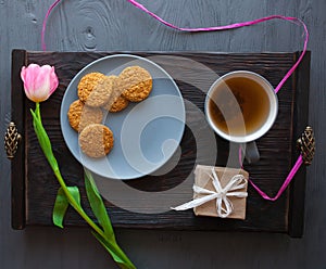 Mother`s Day, woman`s day. tulips , presents , tea and sweets on wooden background