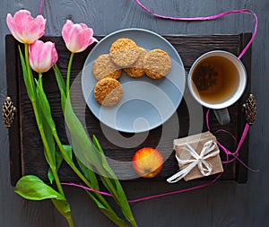 Mother`s Day, woman`s day. tulips ,presents ,tea and sweets on wooden background