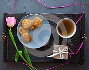 Mother`s Day, woman`s day. tulips ,presents ,tea and sweets on wooden background