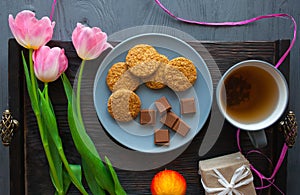 Mother`s Day, woman`s day. tulips ,presents ,tea and sweets on wooden background