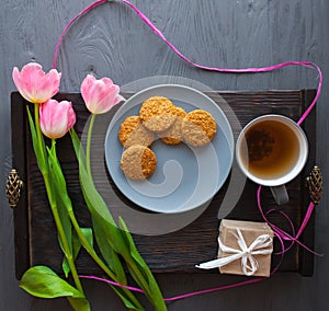 Mother`s Day, woman`s day. tulips ,presents ,tea and sweets on wooden background