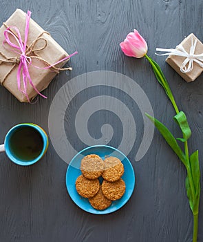 Mother`s Day, woman`s day. tulips ,presents ,tea and sweets on wooden background