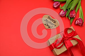 Mother's Day, woman's day. tulips ,presents on wooden white background, greeting card with the inscription