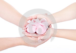 Mothers and fathers hands holding baby booties